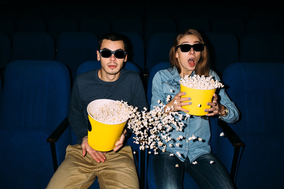 Para w okularach 3D z popcornem na sali kinowej